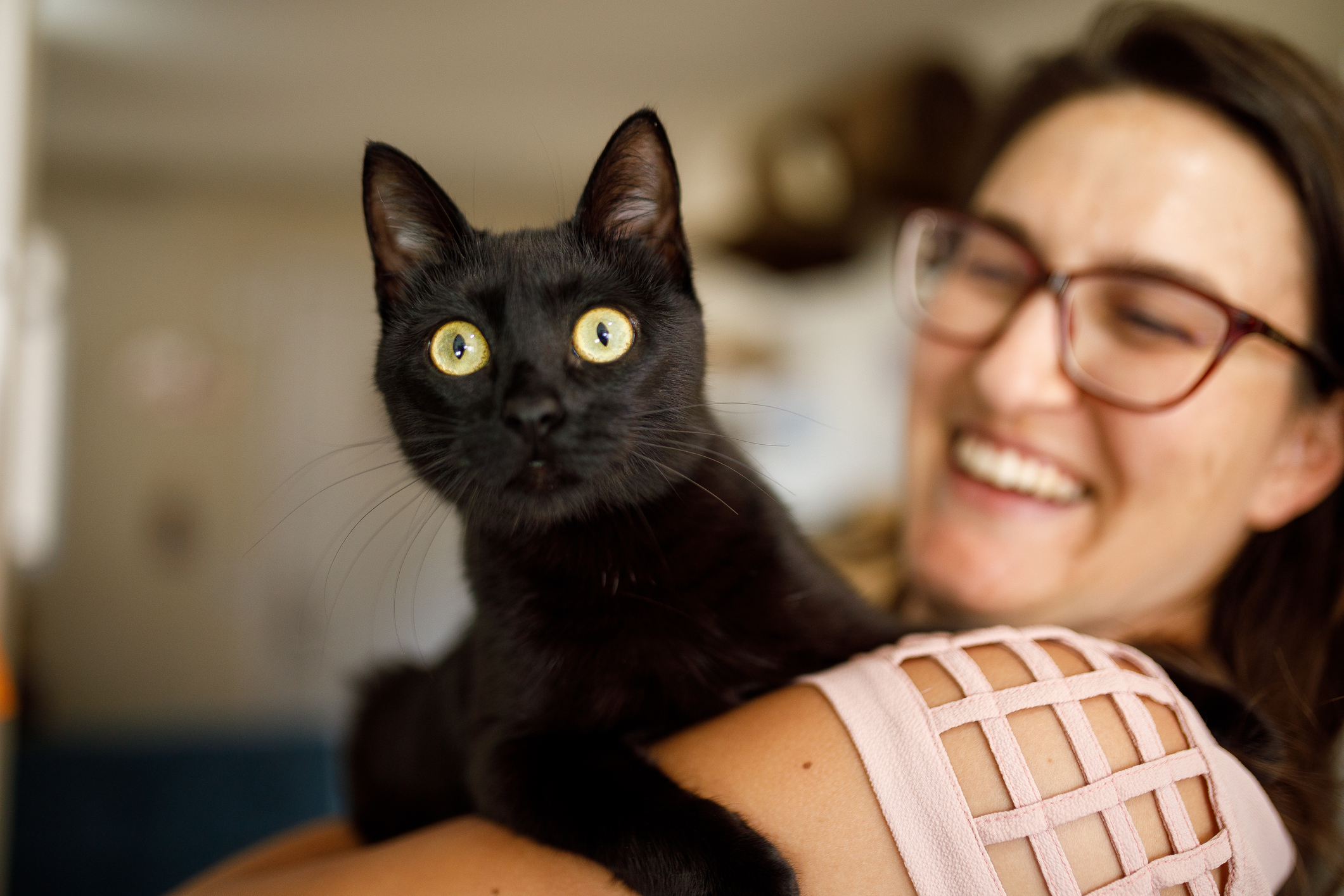 Smiling woman holding black kitten for International Cat Day